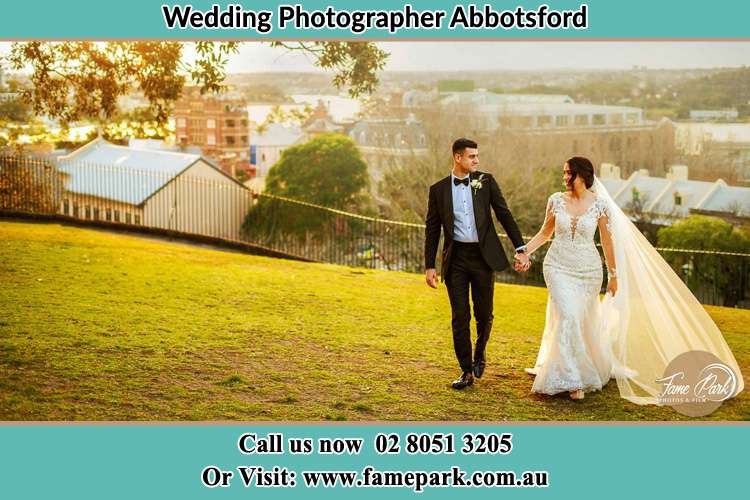 Photo of the Groom and the Bride holding hands while walking at the yard Abbotsford NSW 2046