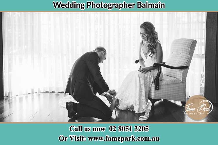 The Bride is being helped by the Groom trying to put on her shoes Balmain NSW 2041