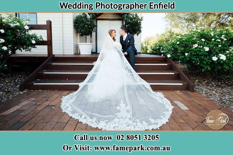 Photo of the Bride and the Groom looking each other while sitting at the staircase Enfield NSW 2136