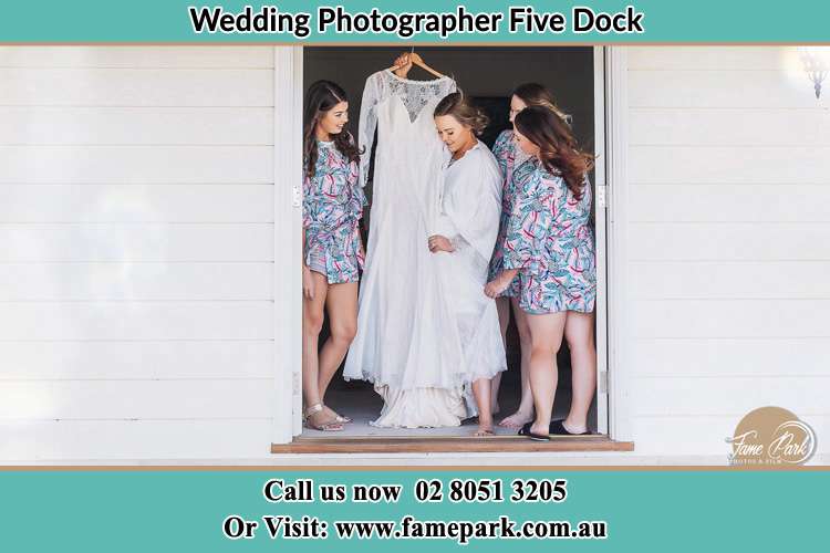 Photo of the Bride and the bridesmaids checking the wedding gown at the door Five Dock NSW 2046