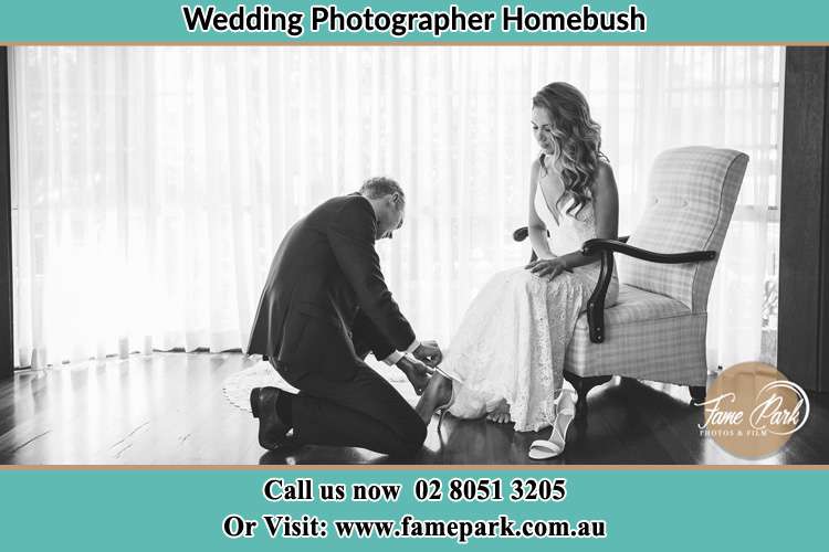 The Bride is being helped by the Groom trying to put on her shoes Homebush NSW 2140