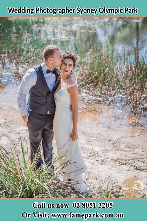 Photo of the Groom kiss the Bride near the lake Sydney Olympic Park NSW 2127